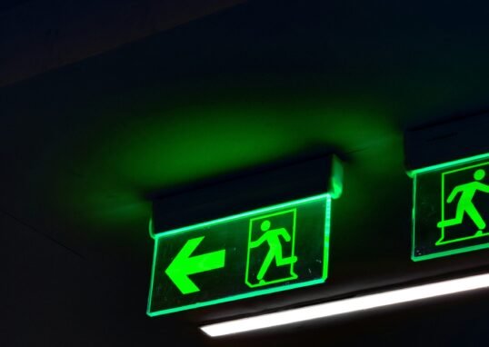 a couple of green signs hanging from the ceiling